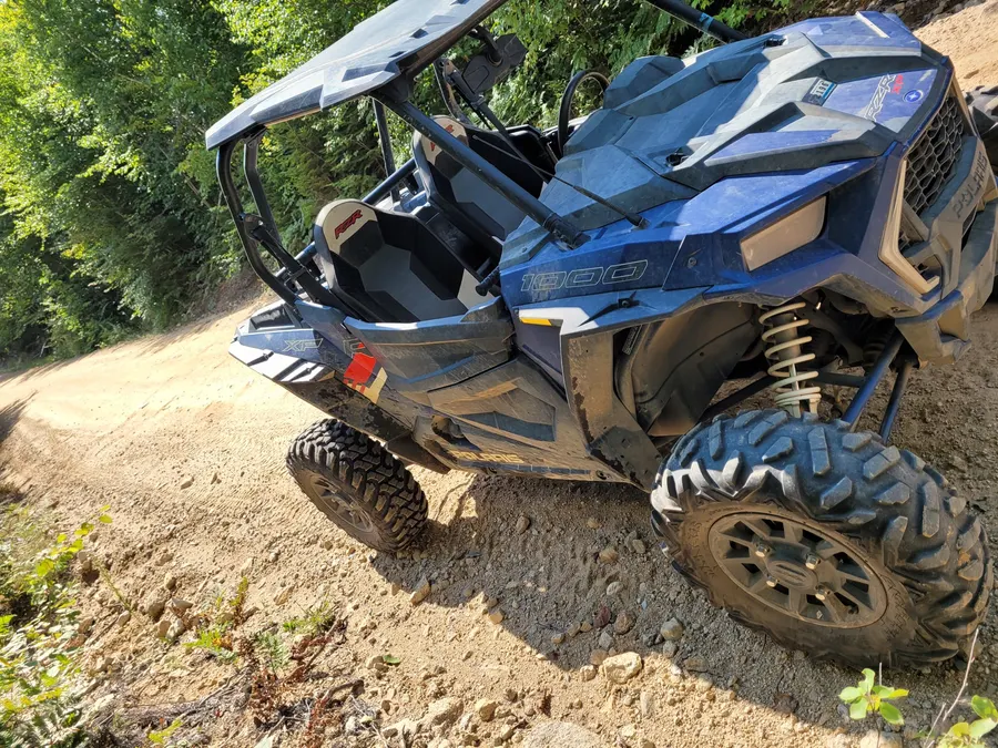 A side-by-side buggy ready to ride on a wooded North Country trail